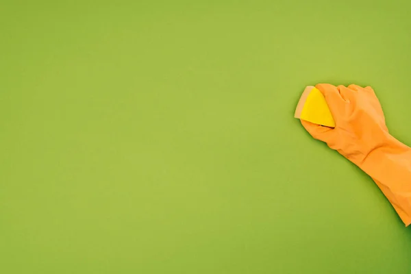 Обрезанный образ женщины очистки с моющей губки изолированы на зеленый — стоковое фото