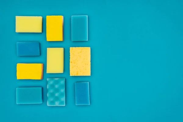 Top view of yellow and blue washing sponges isolated on blue — Stock Photo