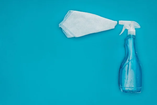 Top view of spray bottle and rag isolated on blue — Stock Photo