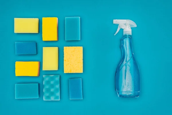 Top view of spray bottle and washing sponges isolated on blue — Stock Photo