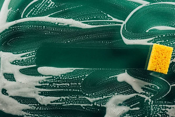 Top view of washing sponge and foam on dirty table — Stock Photo