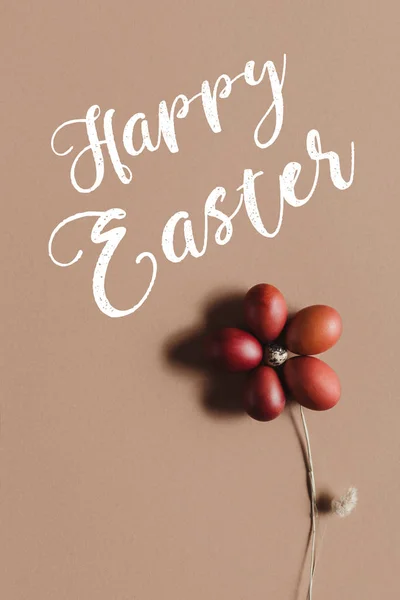 Composición de alimentos de Pascua con flor hecha de huevos en beige con la inscripción Feliz Pascua - foto de stock