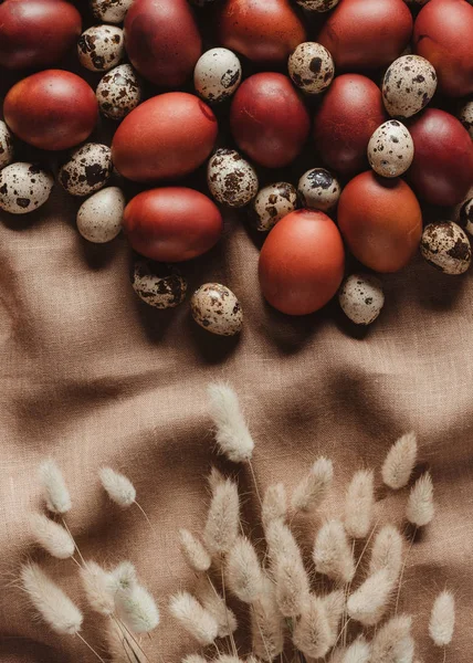 Верхний вид пасхальных куриных яиц и перепелиных яиц на льняной скатерти с ушами — стоковое фото