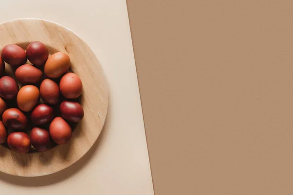 Top view of painted easter eggs on wooden plate — Stock Photo