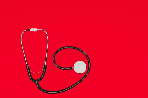 Draufsicht auf Stethoskop isoliert auf roter Oberfläche, Konzept Weltgesundheitstag — Stockfoto