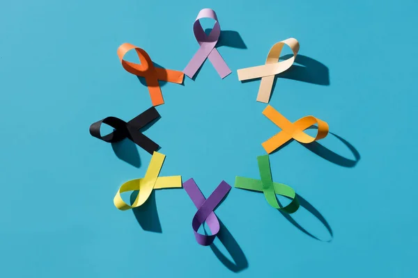 Flat lay with colorful ribbons arranged in circle isolated on blue, world health day concept — Stock Photo
