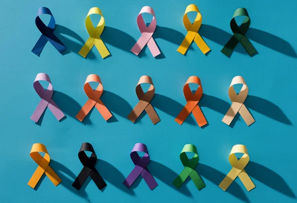 Plano con cintas coloridas dispuestas aisladas en azul, concepto del día de la salud mundial - foto de stock