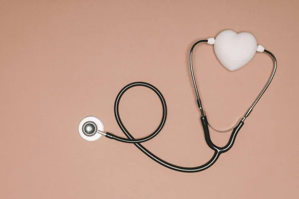 Вид зверху на організоване серце і стетоскоп ізольовані на бежевій поверхні, концепція Всесвітнього дня здоров'я — стокове фото