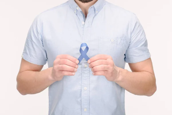 Vue partielle de l'homme avec ruban de sensibilisation bleu isolé sur blanc, concept de cancer du côlon — Photo de stock