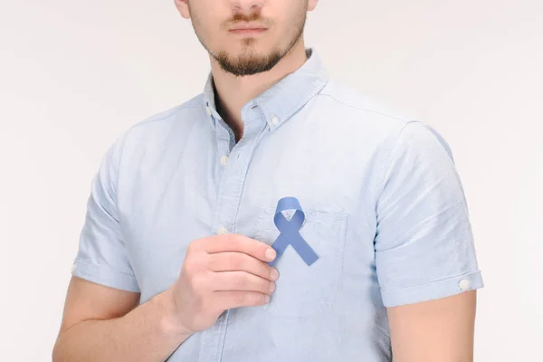 Vue partielle de l'homme avec ruban de sensibilisation bleu isolé sur blanc, concept de cancer du côlon — Photo de stock