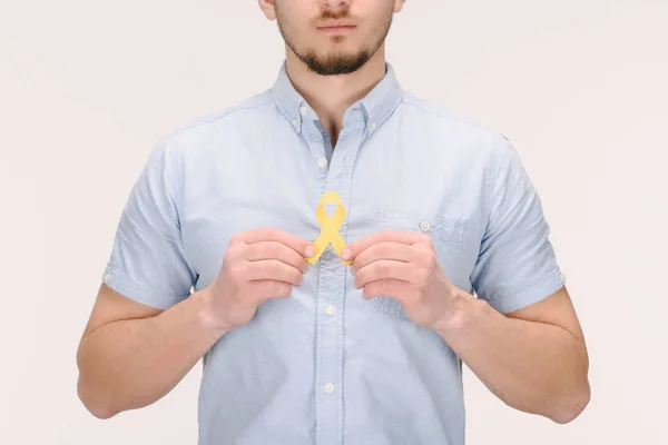 Partial view of man with Childhood Cancer Awareness yellow ribbon isolated on white — Stock Photo
