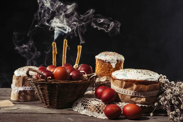 Traditionell bemalte Hühnereier, Kerzen mit Rauch und Osterkuchen mit Kätzchen auf dem Tisch — Stockfoto