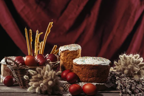 Close-up view of catkins, candles, easter cakes and painted chicken eggs on table — Stock Photo