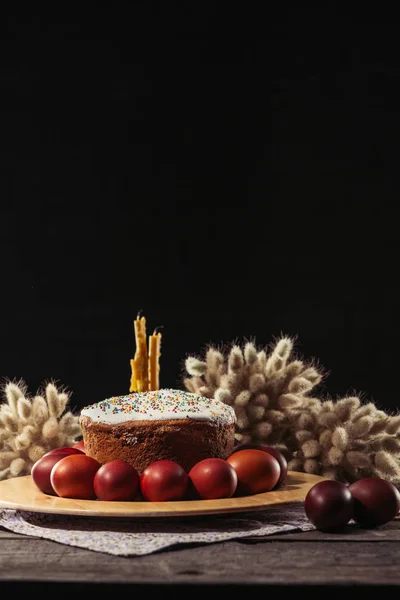 Bemalte Hühnereier, Osterkuchen und Kerzen auf Holztisch — Stockfoto