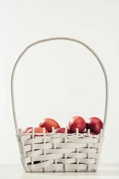 Traditional painted chicken eggs in basket on grey, easter concept — Stock Photo