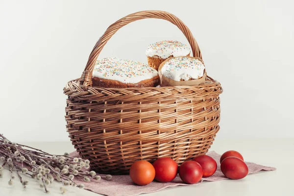 Vue rapprochée du panier avec gâteaux de Pâques, œufs peints et chatons sur gris — Photo de stock