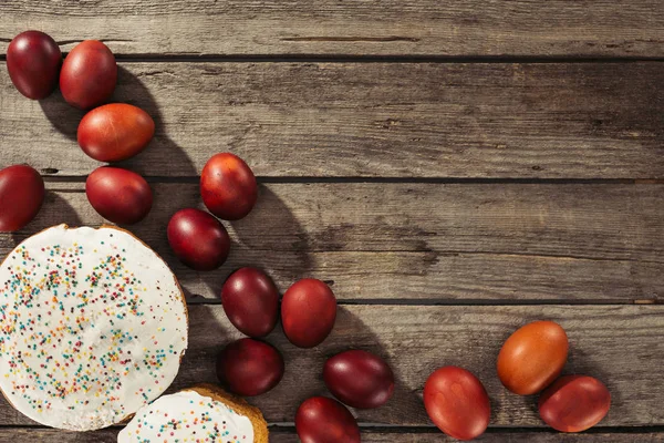 Top view of sweet homemade easter cakes and painted chicken eggs on wooden surface — Stock Photo