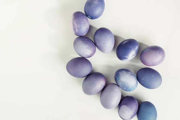 Vista dall'alto delle uova di Pasqua tradizionali dipinte di viola su grigio — Foto stock