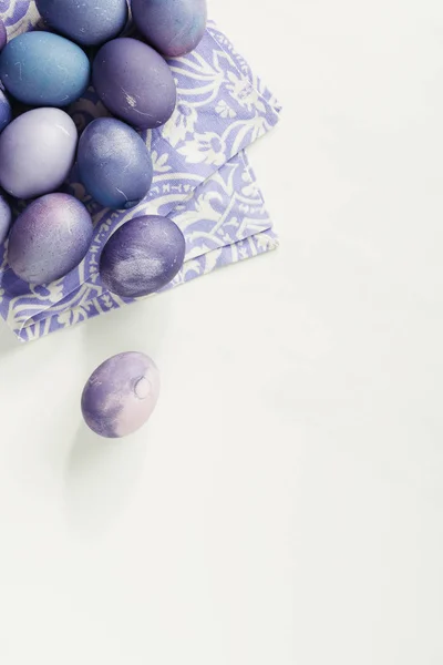 Top view of purple painted easter eggs with napkin on grey — Stock Photo