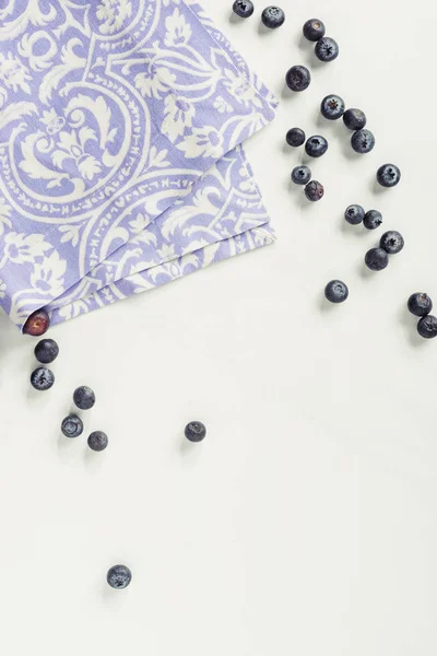 Top view of decorative violet napkin and fresh blueberries on grey — Stock Photo