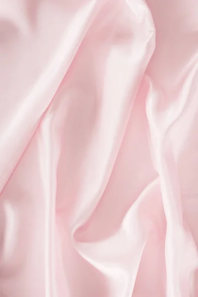 Light pink shiny satin fabric background — Stock Photo