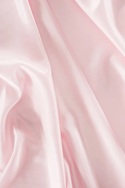 Light pink shiny satin fabric background — Stock Photo