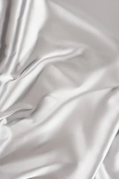 Light silver crumpled shiny silk fabric background — Stock Photo