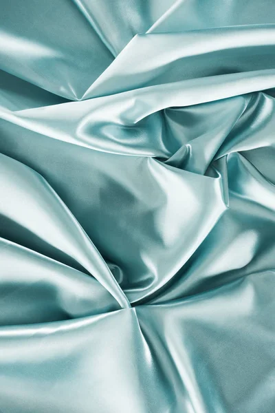 Light turquoise crumpled shiny satin fabric background — Stock Photo