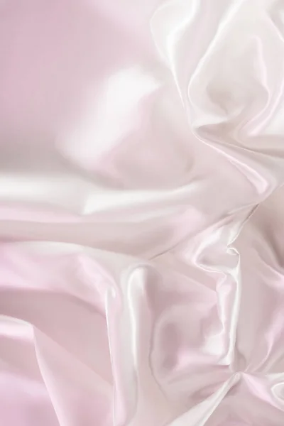 Light pink crumpled shiny silk fabric background — Stock Photo