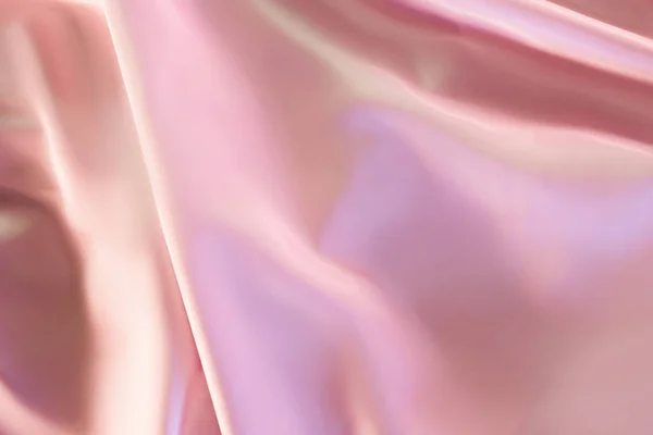 Beige and pink shiny silky fabric background — Stock Photo