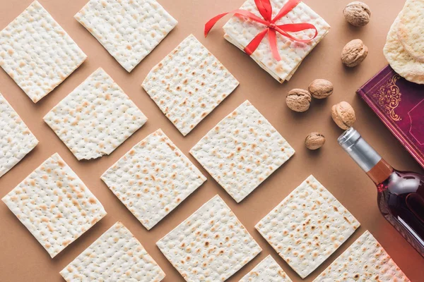 Top view of traditional book with text in hebrew and collection of matza on brown table — Stock Photo