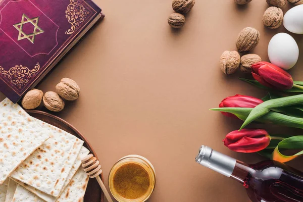 Top view of traditional book with text in hebrew, wine and matza on tabletop — Stock Photo