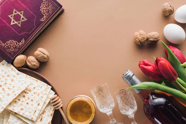 Top view of traditional book with text in hebrew, honey and matza on brown table — Stock Photo