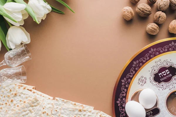Vue du dessus de la plaque juive traditionnelle et matza sur table beige, concept Haggadah Pâque — Photo de stock