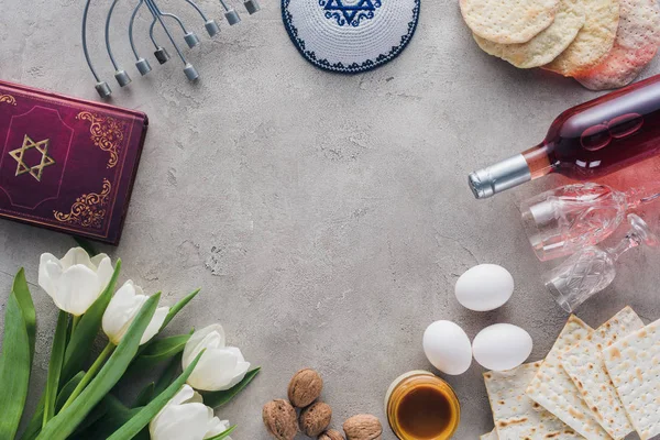 Top view of traditional book with text in hebrew, menorah and kippah on concrete table — Stock Photo