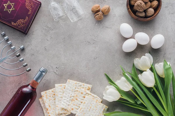 Vue du haut du livre traditionnel avec texte en hébreu et matza sur table en béton — Photo de stock