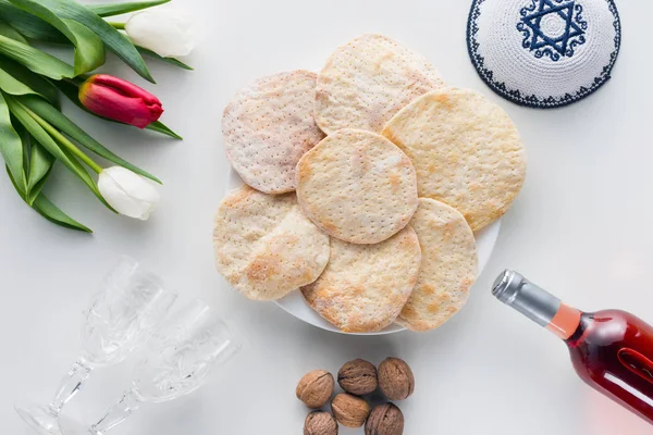 Vista superior de matza y vino en la mesa blanca, concepto de celebración de Pesah - foto de stock