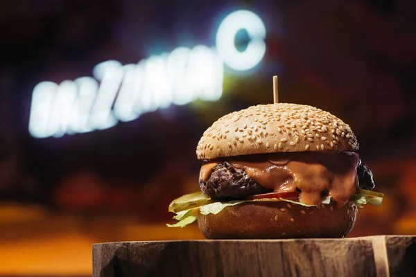 Close-up view of delicious beef burger on wooden stump — Stock Photo