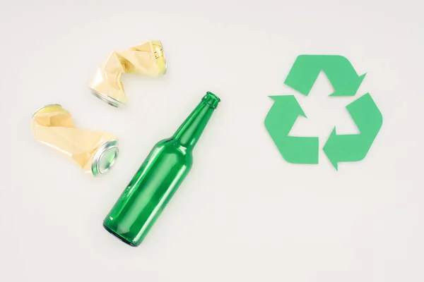 Vista superior de latas de cerveza y botella con cartel de reciclaje en blanco - foto de stock