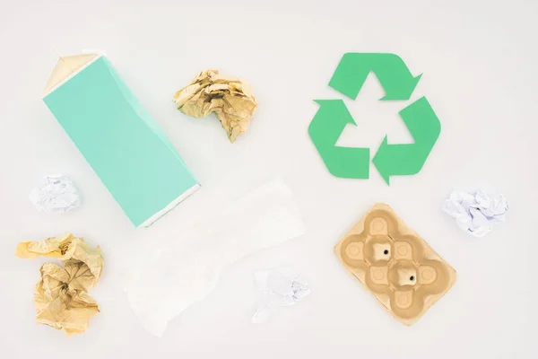 Top view of various paper trash with recycle sign on white — Stock Photo