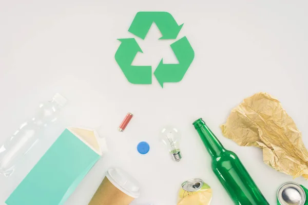 Top view of variation of types of trash with recycle sign on white — Stock Photo