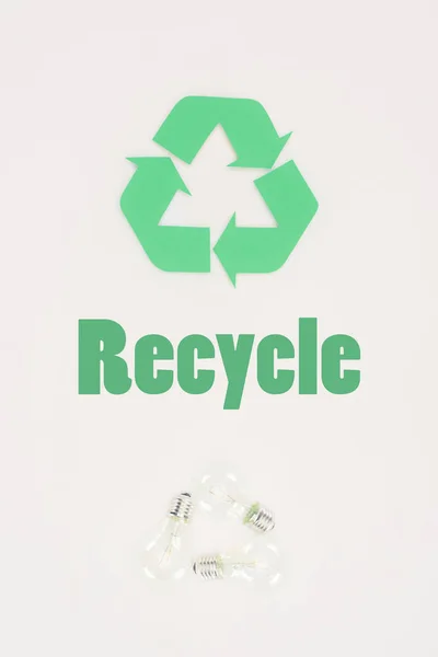 Вид зверху на лампочки зі знаком переробки на білому — стокове фото