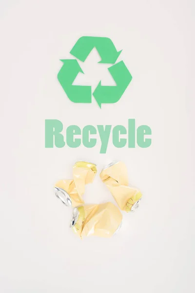 Top view of metal beer cans with recycle sign on white — Stock Photo