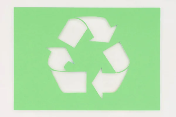 Top view of white arrows recycle sign on green — Stock Photo