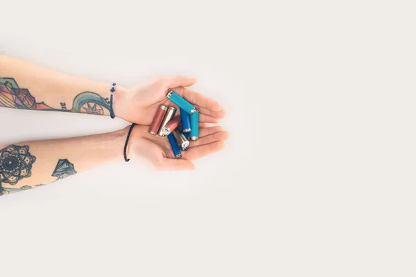 Cropped shot of woman holding batteries in hands isolated on white — Stock Photo