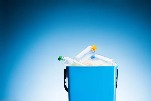 Plastic bottles in trash bin on blue — Stock Photo