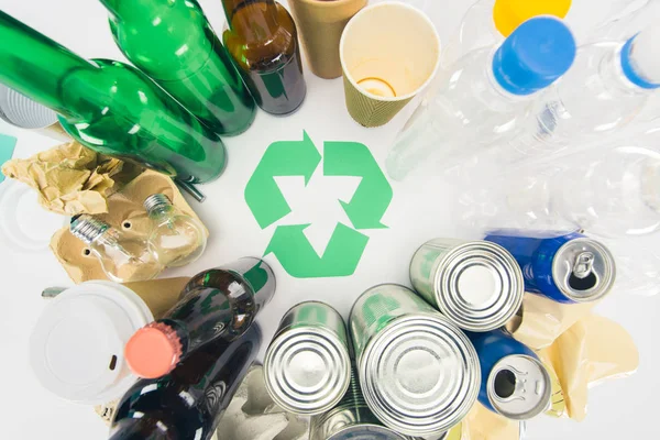 Draufsicht auf verschiedene Arten von Müll mit Recyclingschild auf weiß — Stockfoto