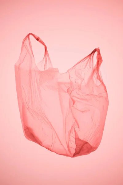 Bolsa de plástico vacía bajo pastel rosa tonificado luz - foto de stock