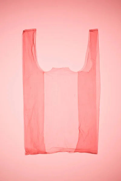 Bolsa de plástico transparente bajo luz tonificada rosa - foto de stock