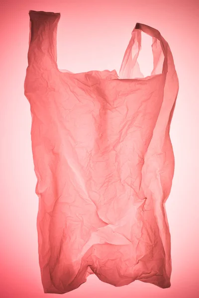 Bolsa de plástico arrugado bajo pastel rosa tonificado luz - foto de stock